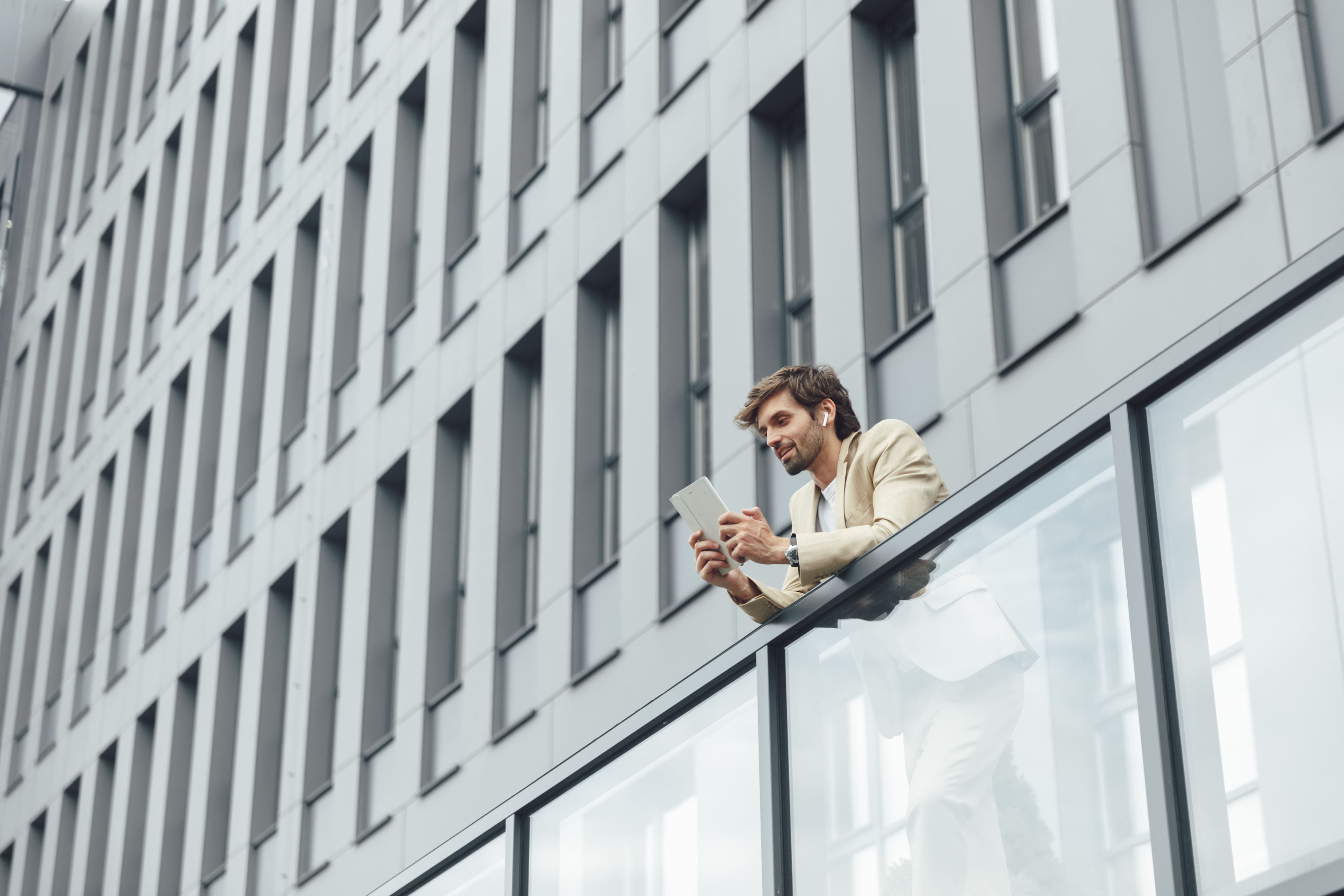 Hombre trabajando con auriculares y tableta digital al aire libre